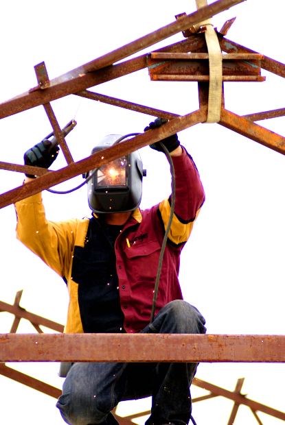 Construction worker high up welding in a compromising position