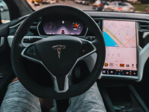 A drivers point of view of a tesla steering wheel and dash.
